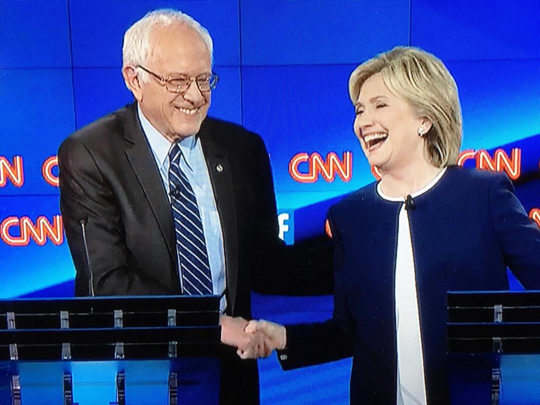 Bernie Sanders and Hillary Clinton shaking hands; Trent Vanegas