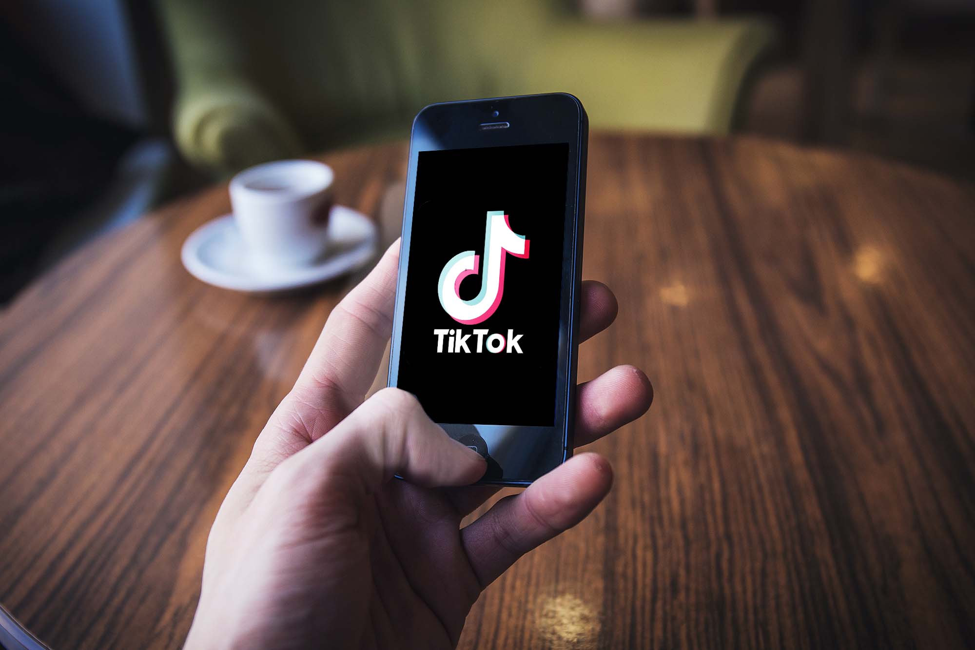 TikTok in a person's hand on table_by Nordskovmedia